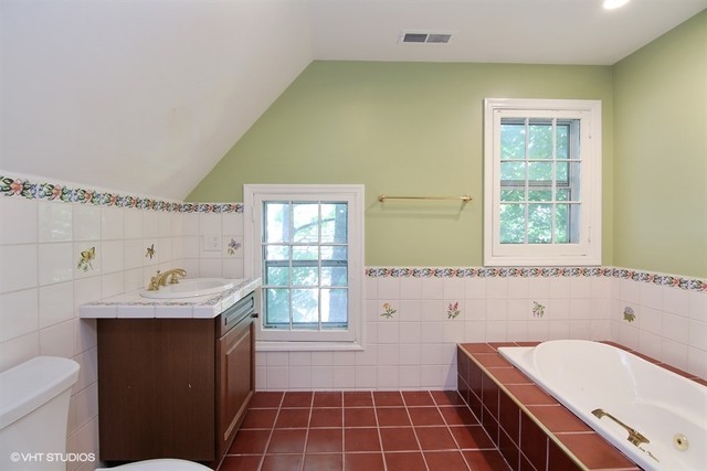 192 Park Avenue Glencoe, IL 60022 - Photo 14 of 24 a bathroom with a tub sink toilet and a window