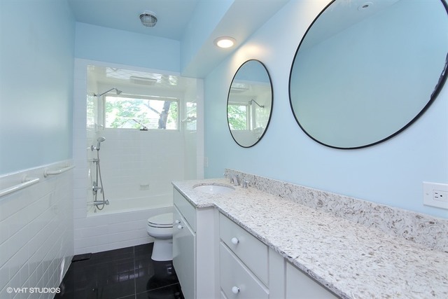192 Park Avenue Glencoe, IL 60022 - Photo 15 of 24 a bathroom with a granite countertop sink a toilet and a mirror