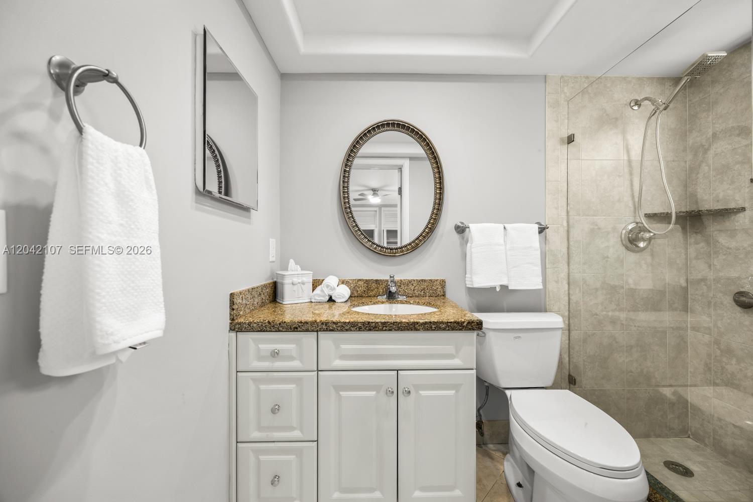 3213 Colony Club Road, Unit 3E Pompano Beach, FL 33062 - Photo 23 of 31 a bathroom with a toilet sink vanity and mirror