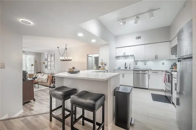a kitchen with cabinets and chairs
