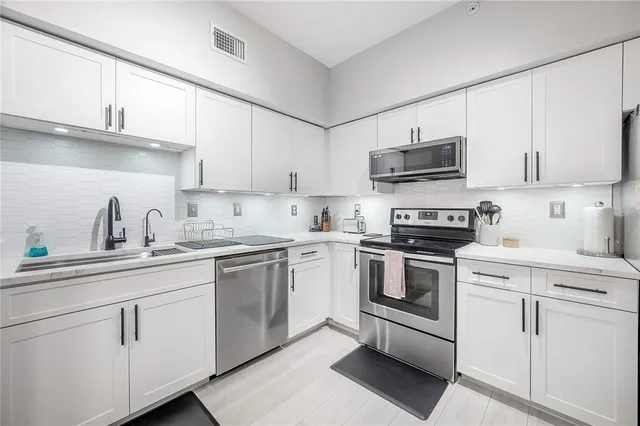 a kitchen with cabinets stainless steel appliances and a sink