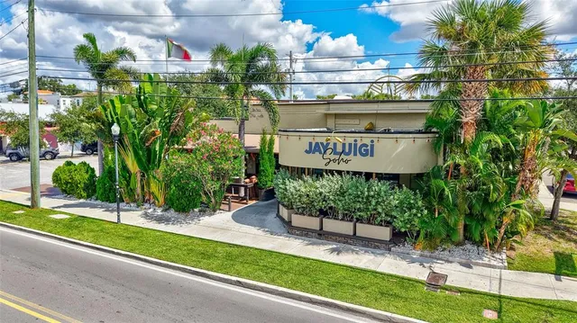 a view of a house with large windows and a small yard