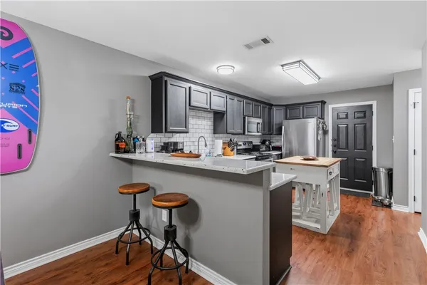 a kitchen with kitchen island a wooden floor and white stainless steel appliances