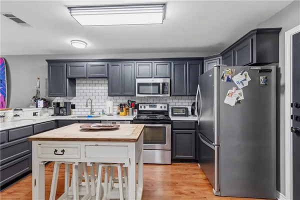 a kitchen with stainless steel appliances a stove a sink and a refrigerator