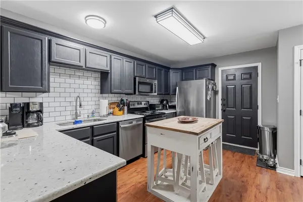 a kitchen with stainless steel appliances granite countertop a stove refrigerator sink and cabinets