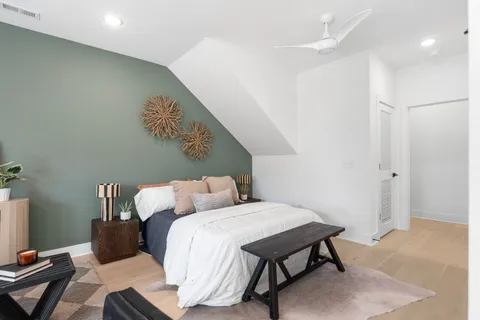 a spacious bedroom with a bed and glass table