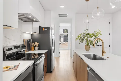 a kitchen with stainless steel appliances kitchen island a sink stove and refrigerator