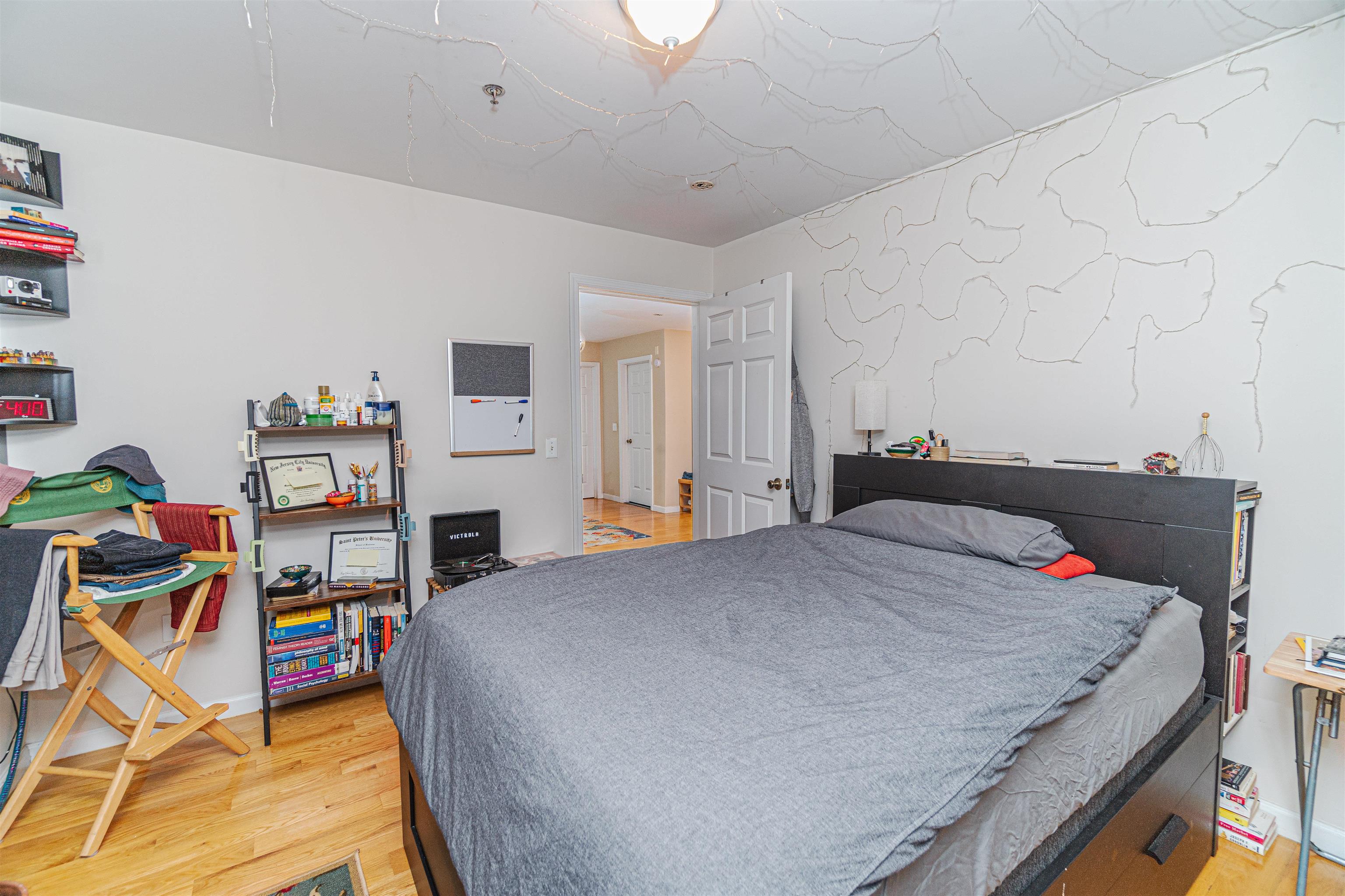 135 38th Street, Unit 302 Union City, NJ 07087 - Photo 14 of 18 a bed room with a bed and a book shelf