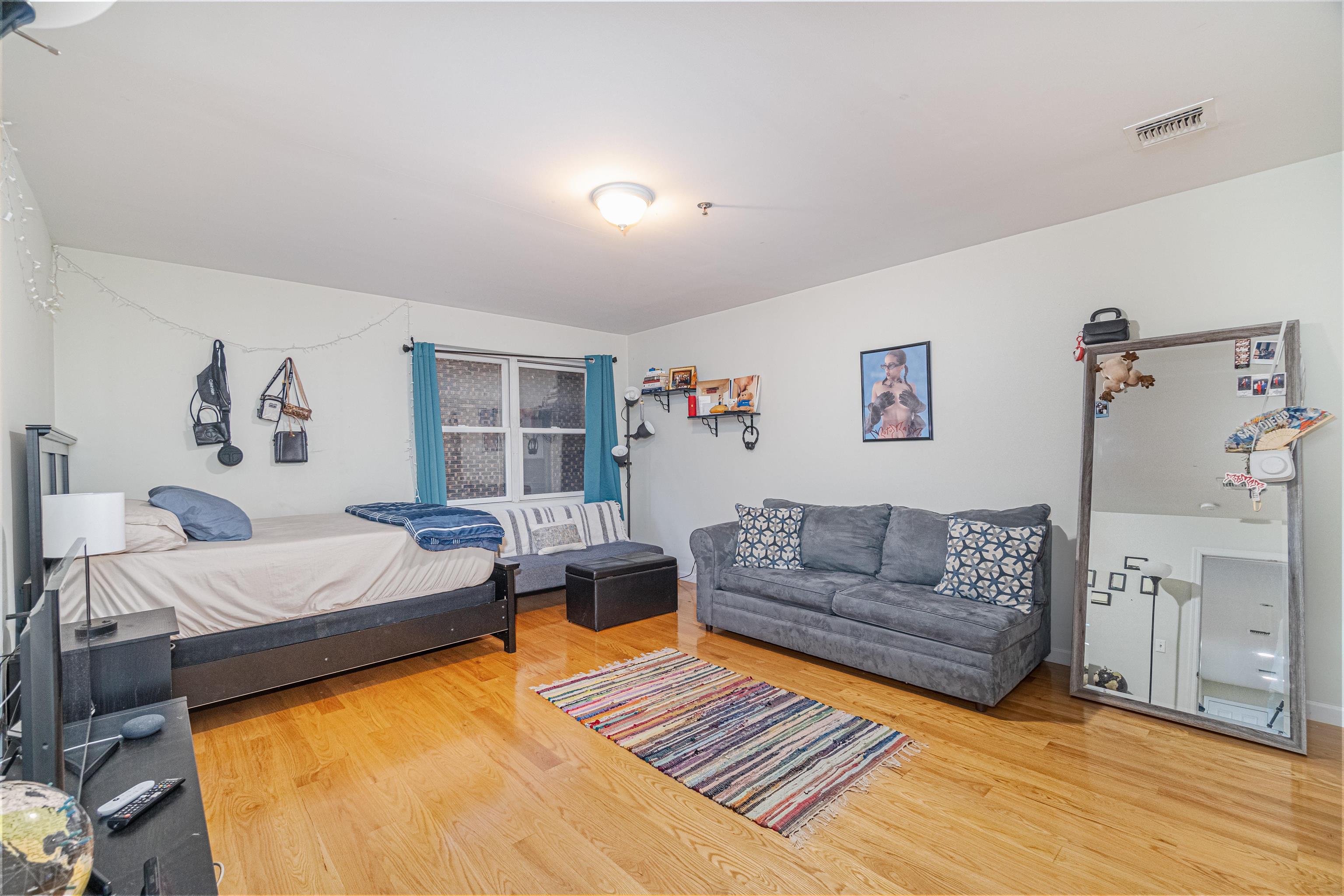 135 38th Street, Unit 302 Union City, NJ 07087 - Photo 16 of 18 a living room with furniture and a couch