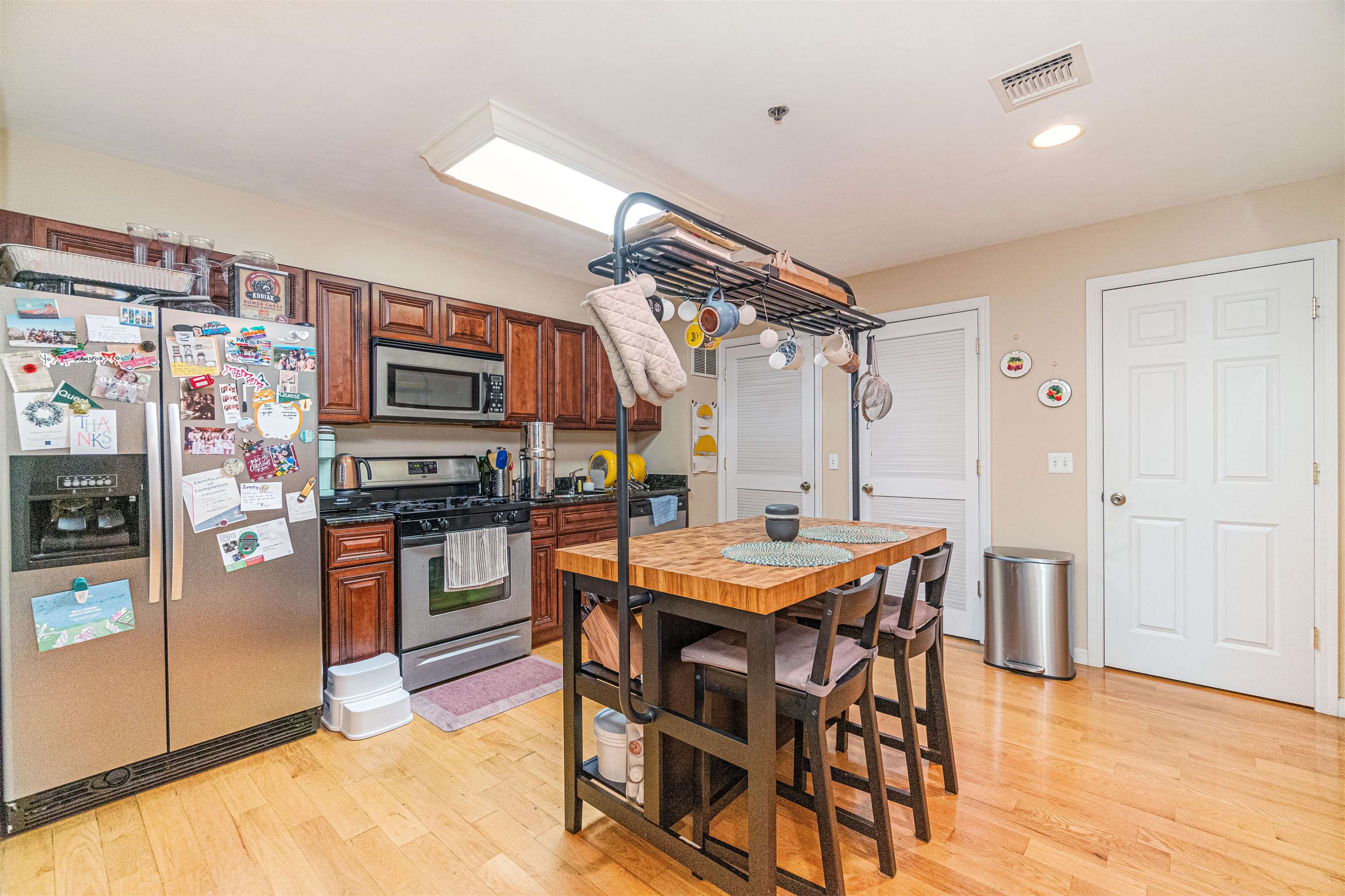135 38th Street, Unit 302 Union City, NJ 07087 - Photo 9 of 18 a kitchen with stainless steel appliances a stove a refrigerator and a dining table