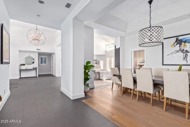 a view of a livingroom and dining room with furniture wooden floor and a chandelier