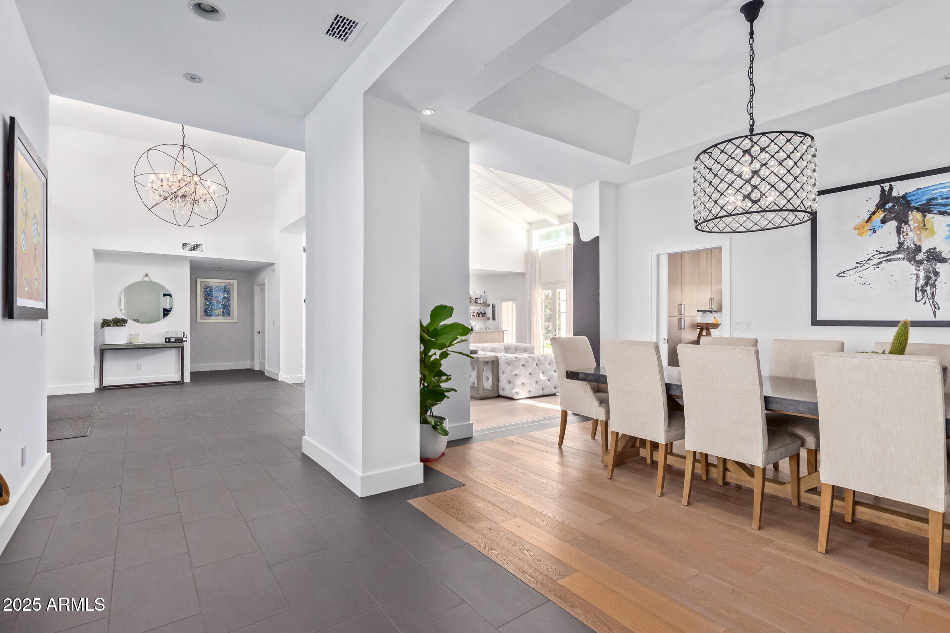 a view of a livingroom and dining room with furniture wooden floor and a chandelier