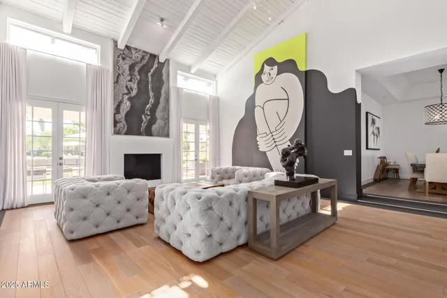 a living room with furniture a fireplace and a chandelier