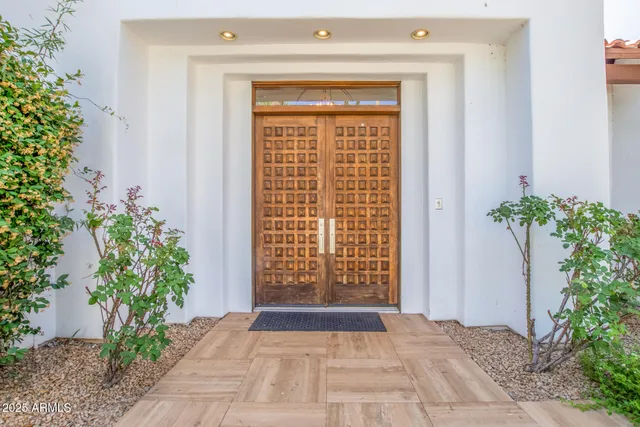 a view of front door with potted plants