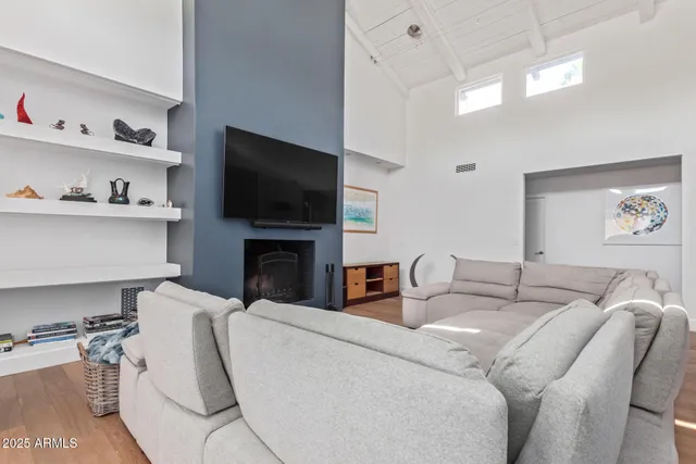 a living room with furniture a flat screen tv and a fireplace