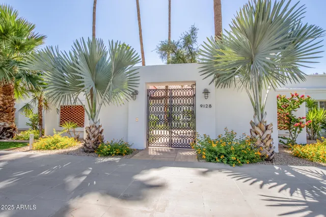 a couple of palm trees in front of yellow house