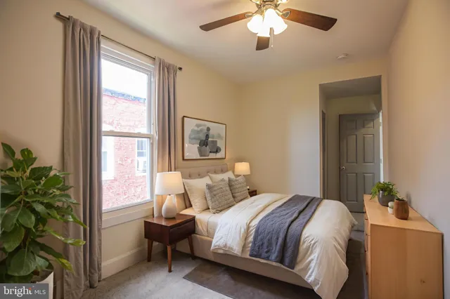 a bedroom with a large bed and a chandelier