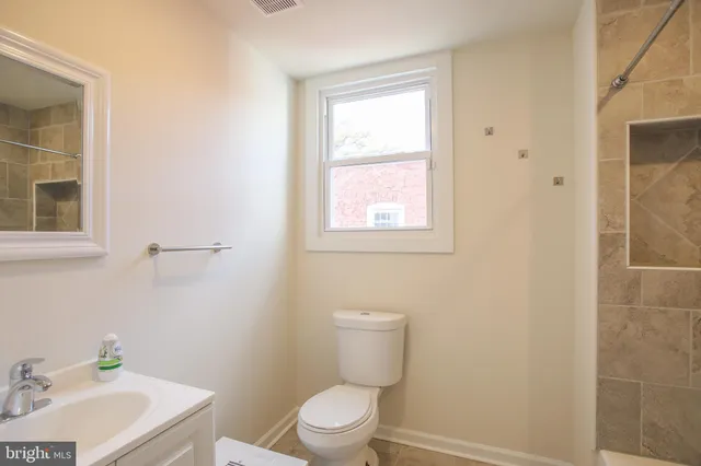 a bathroom with a sink a toilet and a mirror