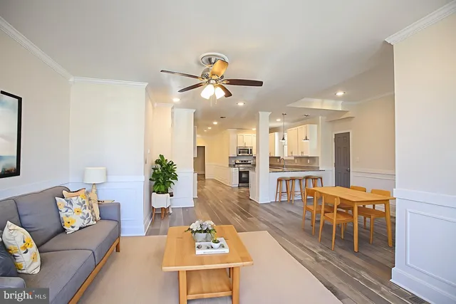a living room with furniture kitchen view and a chandelier