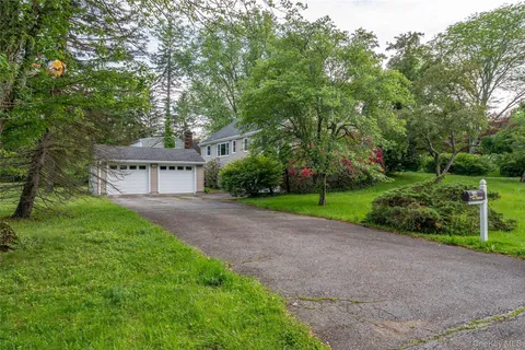 a view of a house with a yard and a large tree