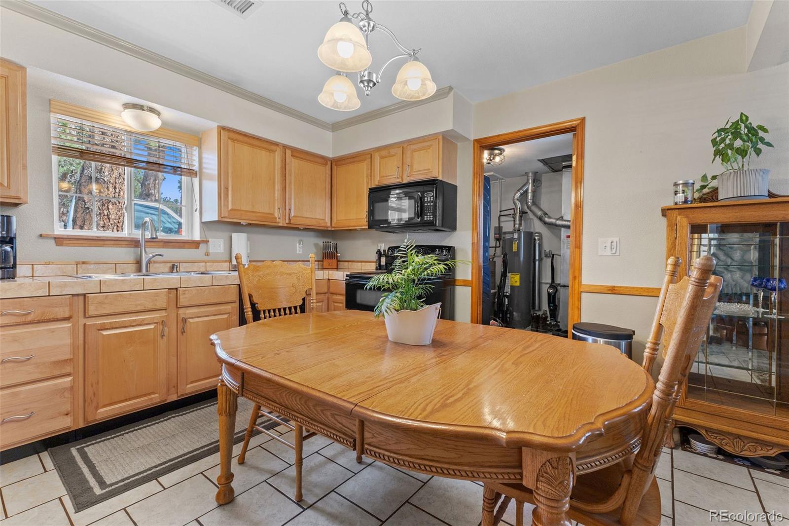 161 Sullivan Street Bailey, CO 80421 - Photo 6 of 32 a kitchen with stainless steel appliances a table chairs and a refrigerator