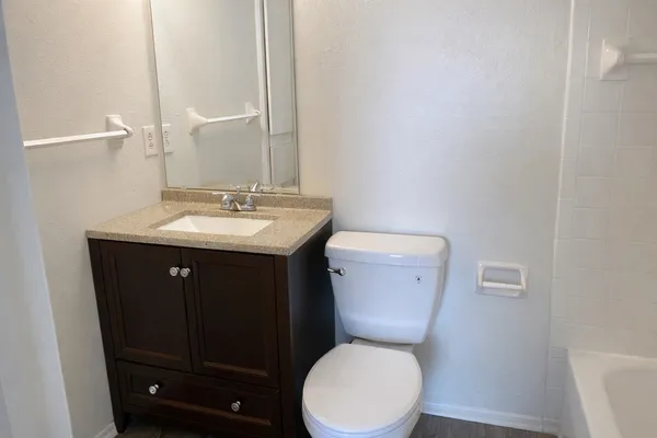 a bathroom with a toilet a sink a vanity and mirror