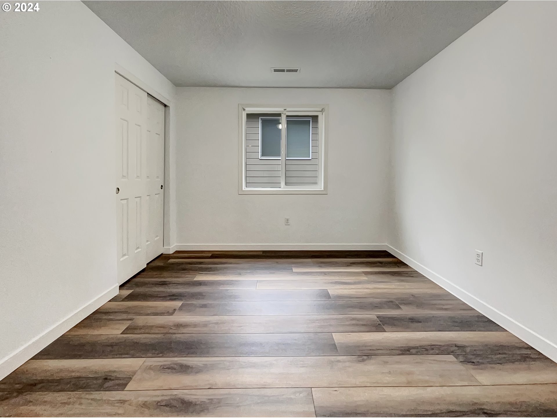 2933 South Cedar Ridge Drive Ridgefield, WA 98642 - Photo 10 of 21 a view of an empty room with wooden floor and a window
