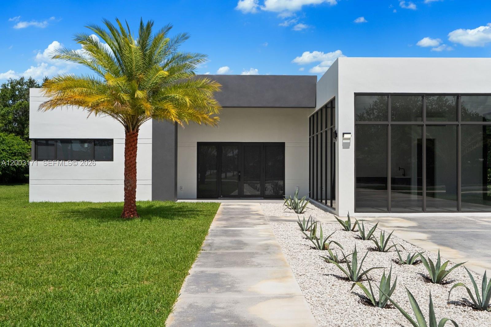 29705 Southwest 187th Avenue Homestead, FL 33030 - Photo 1 of 55 a front view of a house having yard