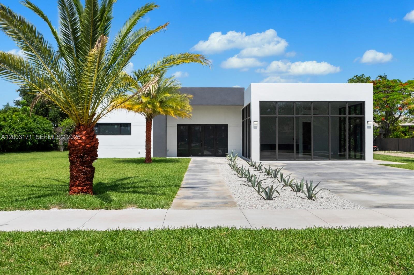 29705 Southwest 187th Avenue Homestead, FL 33030 - Photo 37 of 55 a front view of a house with a garden and yard