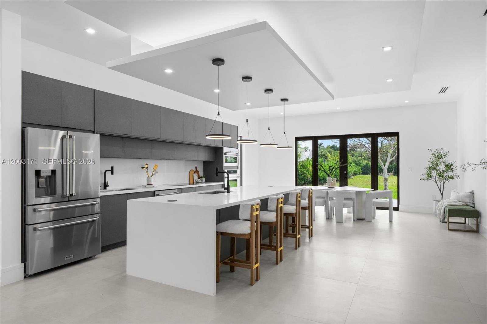 29705 Southwest 187th Avenue Homestead, FL 33030 - Photo 4 of 55 a kitchen with stainless steel appliances a stove a refrigerator a kitchen island a couches and a dining table with garden view