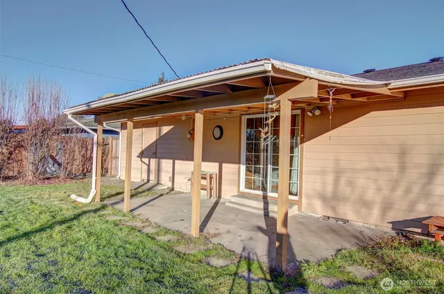 a view of backyard with wooden fence and a large tree