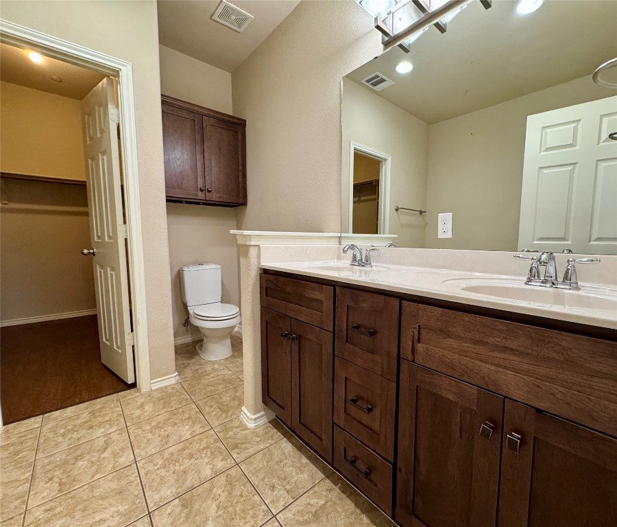 3101 Davis Lane, Unit 8703 Austin, TX 78748 - Photo 11 of 23 a spacious bathroom with a double vanity sink a toilet and a mirror