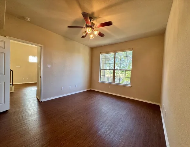 a view of a livingroom with wooden floor and a ceiling fan