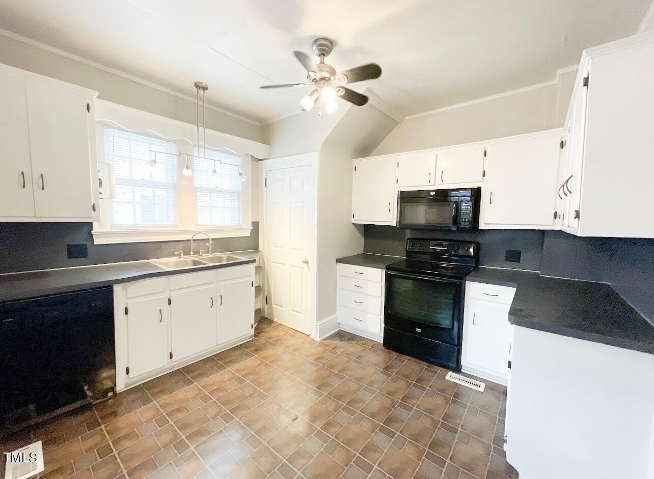 237 Wesleyan Heights Road Roxboro, NC 27573 - Photo 12 of 39 a kitchen with granite countertop white cabinets a counter top space stainless steel appliances and a window