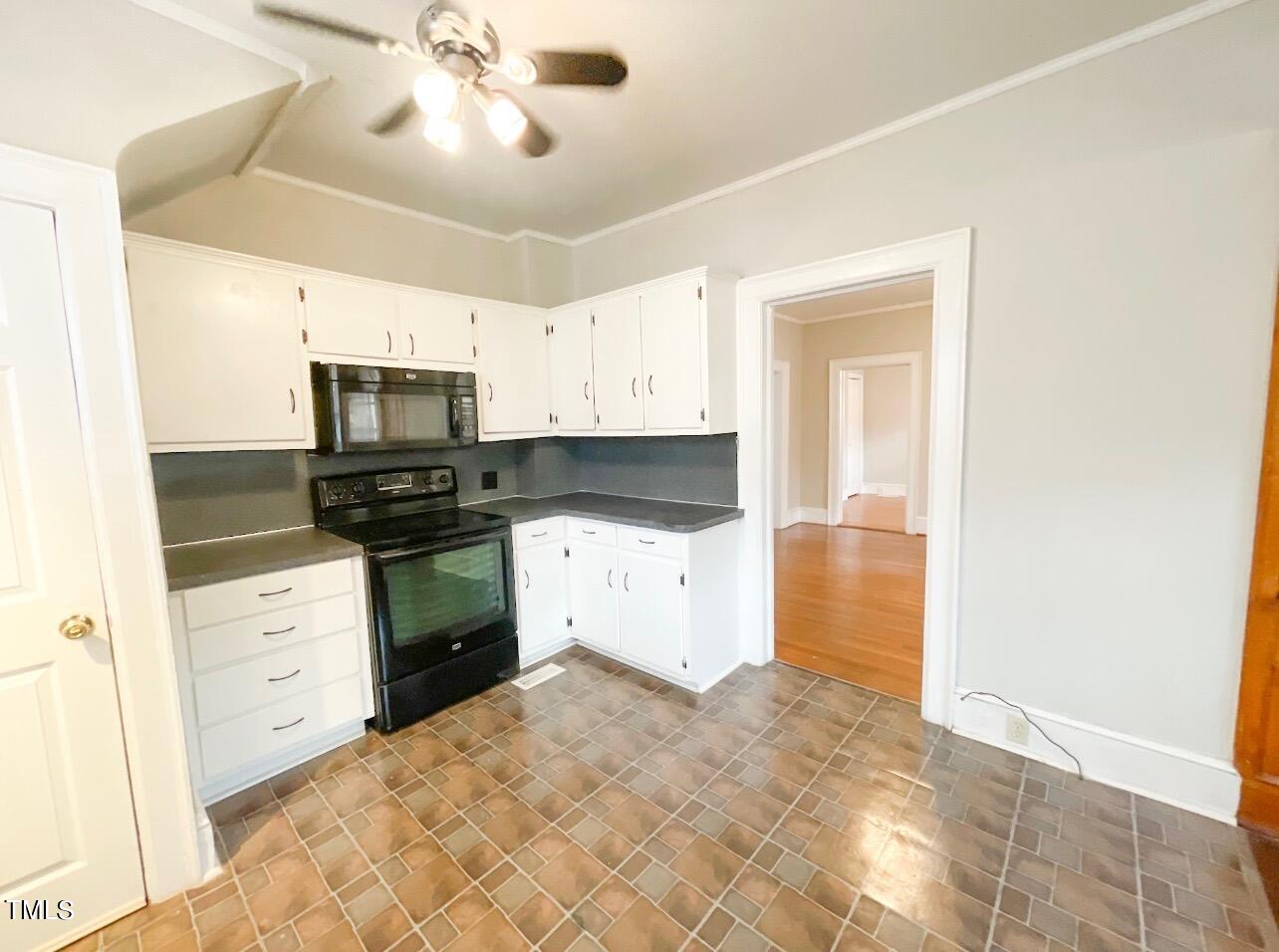 237 Wesleyan Heights Road Roxboro, NC 27573 - Photo 14 of 39 a kitchen with white cabinets and appliances