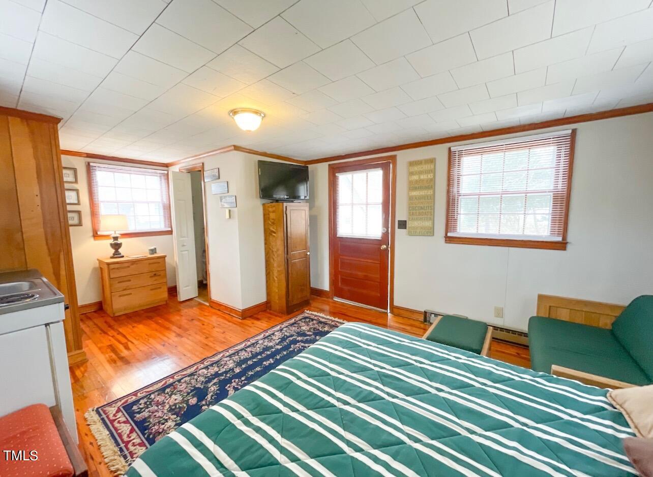 237 Wesleyan Heights Road Roxboro, NC 27573 - Photo 36 of 39 a bedroom with a bed and wooden floor