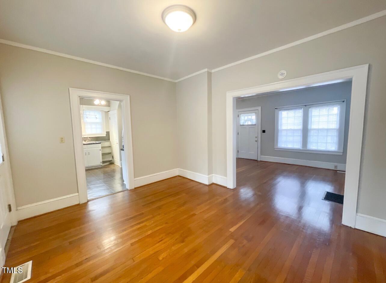 237 Wesleyan Heights Road Roxboro, NC 27573 - Photo 10 of 39 a view of empty room with wooden floor and kitchen