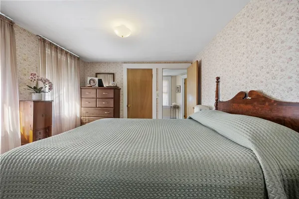a bedroom with a large bed and dresser
