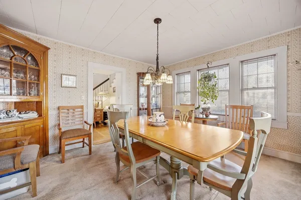 a dining room with furniture a chandelier and wooden floor