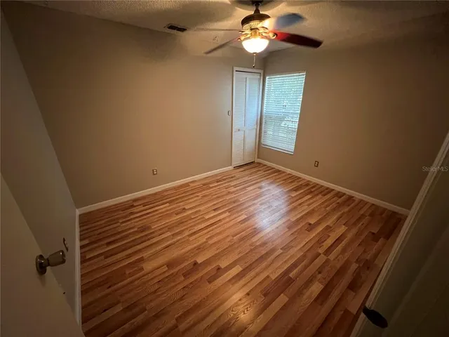 a view of an empty room with a chandelier fan