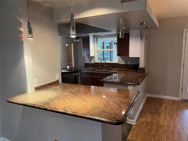 a kitchen with granite countertop a sink and cabinets