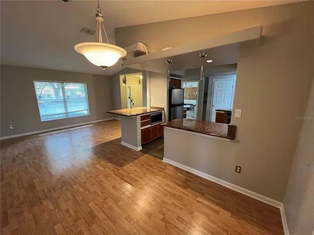 an open kitchen with chandelier and stainless steel appliances