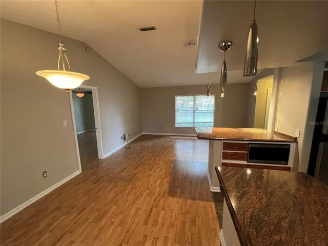 a kitchen with granite countertop a stove and a wooden floor