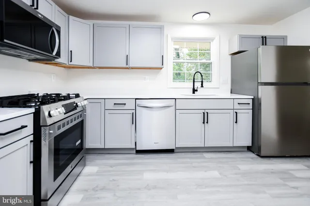 a kitchen with stainless steel appliances a stove microwave and refrigerator