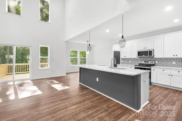 a kitchen with stainless steel appliances granite countertop a stove a sink and a wooden floors