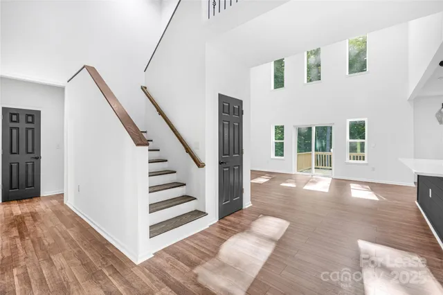 a view of a hallway with wooden floor and staircase