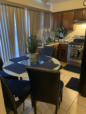 a kitchen with a table chairs stove and cabinets