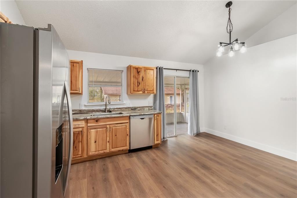 7670 Southwest 80th Place Ocala, FL 34476 - Photo 13 of 44 a kitchen with stainless steel appliances granite countertop a refrigerator a sink dishwasher a stove and white countertops with wooden floor