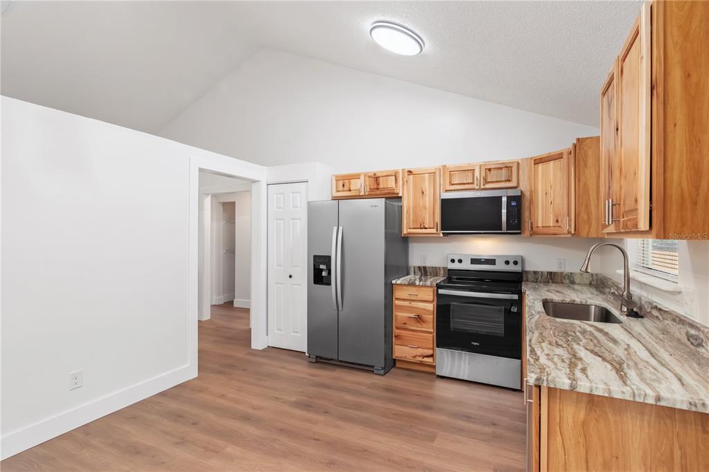 7670 Southwest 80th Place Ocala, FL 34476 - Photo 16 of 44 a kitchen with stainless steel appliances a stove top oven a sink and a refrigerator