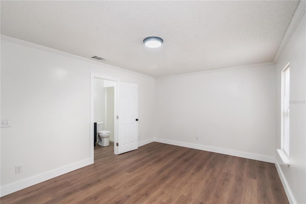 7670 Southwest 80th Place Ocala, FL 34476 - Photo 17 of 44 an empty room with wooden floor and windows